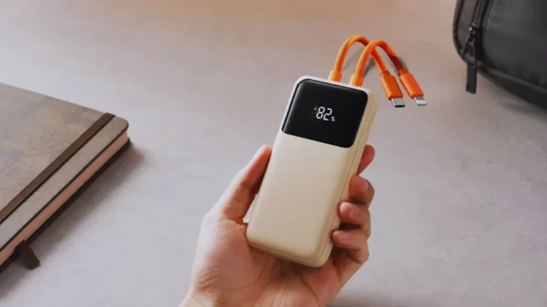 Compact power bank with built-in orange charging cables and digital battery display