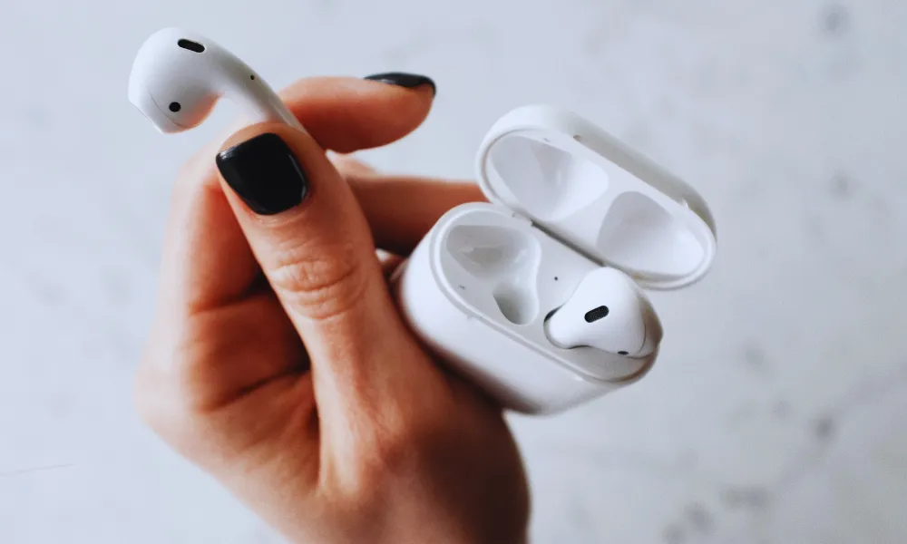 Close-up of a white AirPods charging case showing the USB-C port and speaker holes.
